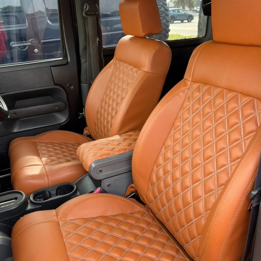 Brown leather car seats with diamond stitching inside a vehicle.